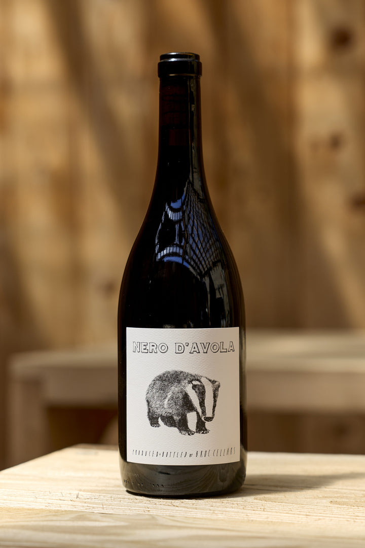 A bottle of 2023 Nero D’Avola by Broc Cellars with a label featuring an illustration of a badger.