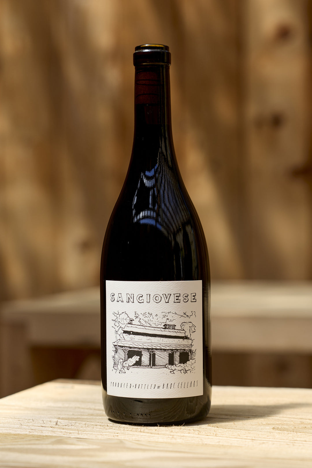 A bottle of 2025 Sangiovese by Broc Cellars, featuring a label with an illustration of a building and known for its food-friendly acidity and gentle tannins.