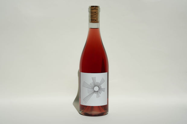A 2024 OSunshine bottle of rosé wine from Broc Cellars, CCOF Certified Organic, stands upright with a cork top and a white label featuring a black geometric sunburst design against a plain light background.