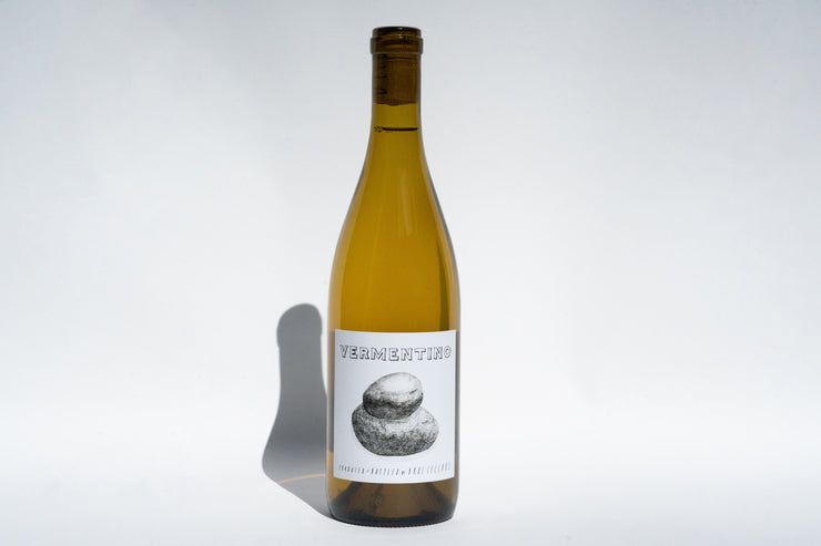 A bottle of 2023 Fox Hill Vermentino from Broc Cellars, with a white label saying VERMENTINO and an abstract stone sculpture image, casts a shadow on a plain white background, embodying Mendocinos artistry.