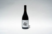 A bottle of 2023 Nero DAvola wine from Broc Cellars is centered against a plain white background. The label features an intricate animal illustration and text, highlighting its Mendocino origin, with the bottles shadow faintly visible on the surface.