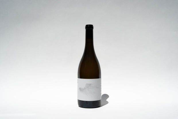 A tall, dark wine bottle with a minimalist label sits against a white background. Featuring a subtle feather design, this 2023 Michael Mara Chardonnay from Broc Cellars is centered and casts a soft shadow on the surface, inviting thoughts of the rich flavors found in Sonoma Coast AVA.