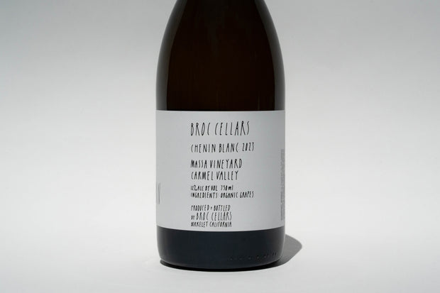 The minimalist white label reads: Broc Cellars, 2023 Happī Chenin, with alcohol and production details stating it is crafted and bottled by Broc Cellars in Berkeley, California.