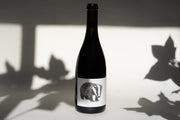 The 2015 Nero d’Avola from Broc Cellars features a black and white badger label. Set against a simple background with leaf shadows on the wall, its predominantly dark color mirrors its mysterious allure.