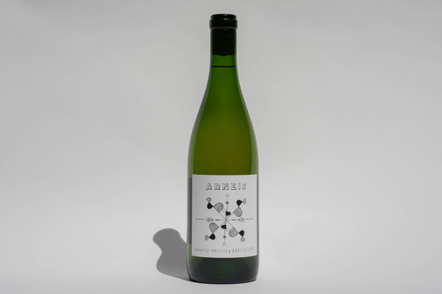 A green bottle of Broc Cellars 2024 Arneis stands upright on a plain light gray background, featuring a white label with “ARNEIS” and a geometric black-and-white design.