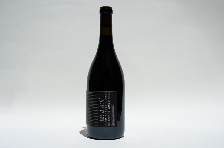A dark glass bottle of 2023 Broc Valdiguié by Broc Cellars stands upright on a plain white background, featuring a black and white label with vertical and horizontal text that highlights heritage vines from Wirth Ranch.