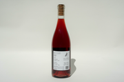 A clear glass bottle of 2024 Ayay! red wine from Broc Cellars, sealed with a cork and featuring a white label with black text, stands upright against a plain white background.