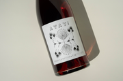 A bottle of Broc Cellars 2024 Ayay! wine with a white label featuring AYAY! in bold and a black plant design, photographed on a light background with a shadow—showcasing Trebbiano from Fox Hill Vineyard.