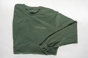 The Fox Hill Organic Long Sleeve Shirt by Broc Cellars, in forest green and made from 100% cotton, is laid flat on a white surface. Small, centered chest text reads CERTIFIED HUMAN.