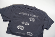 A dark gray unisex Broc Amore Rosso T-Shirt by Broc Cellars lies flat, showing the back with the Amore Rosso logo above four illustrated oyster shells and “DNO CELLARS” printed near the bottom.